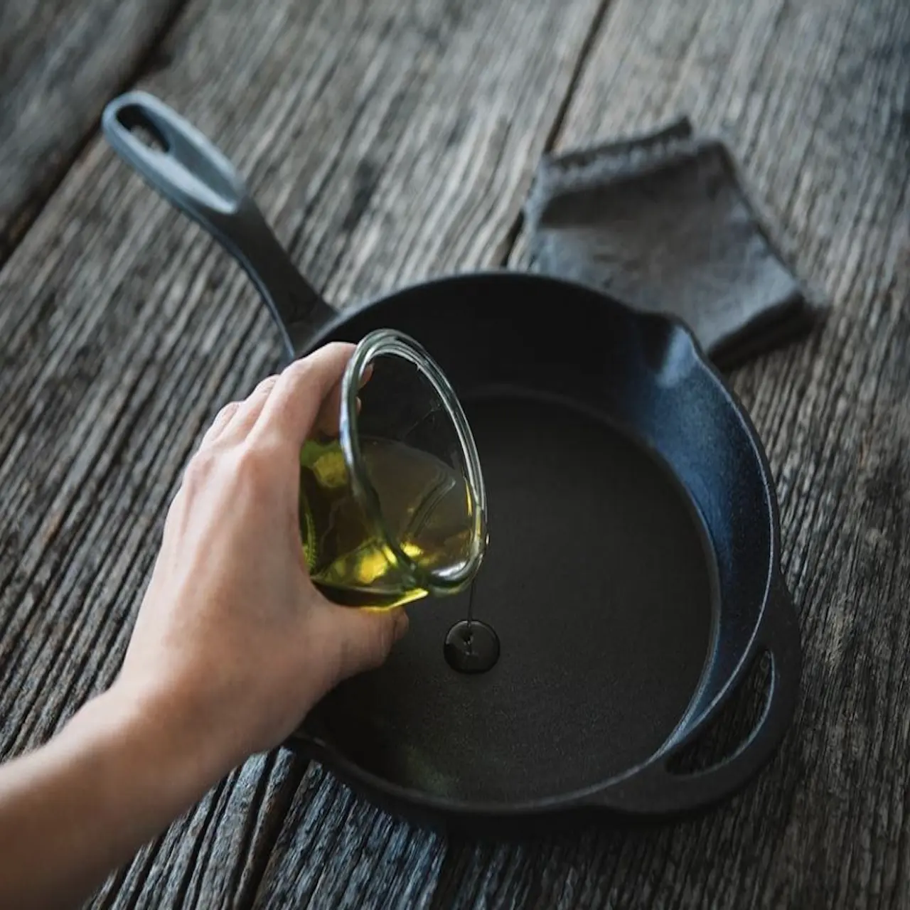 Limpieza y mantenimiento de una sartén de hierro fundido con papel de cocina y aceite