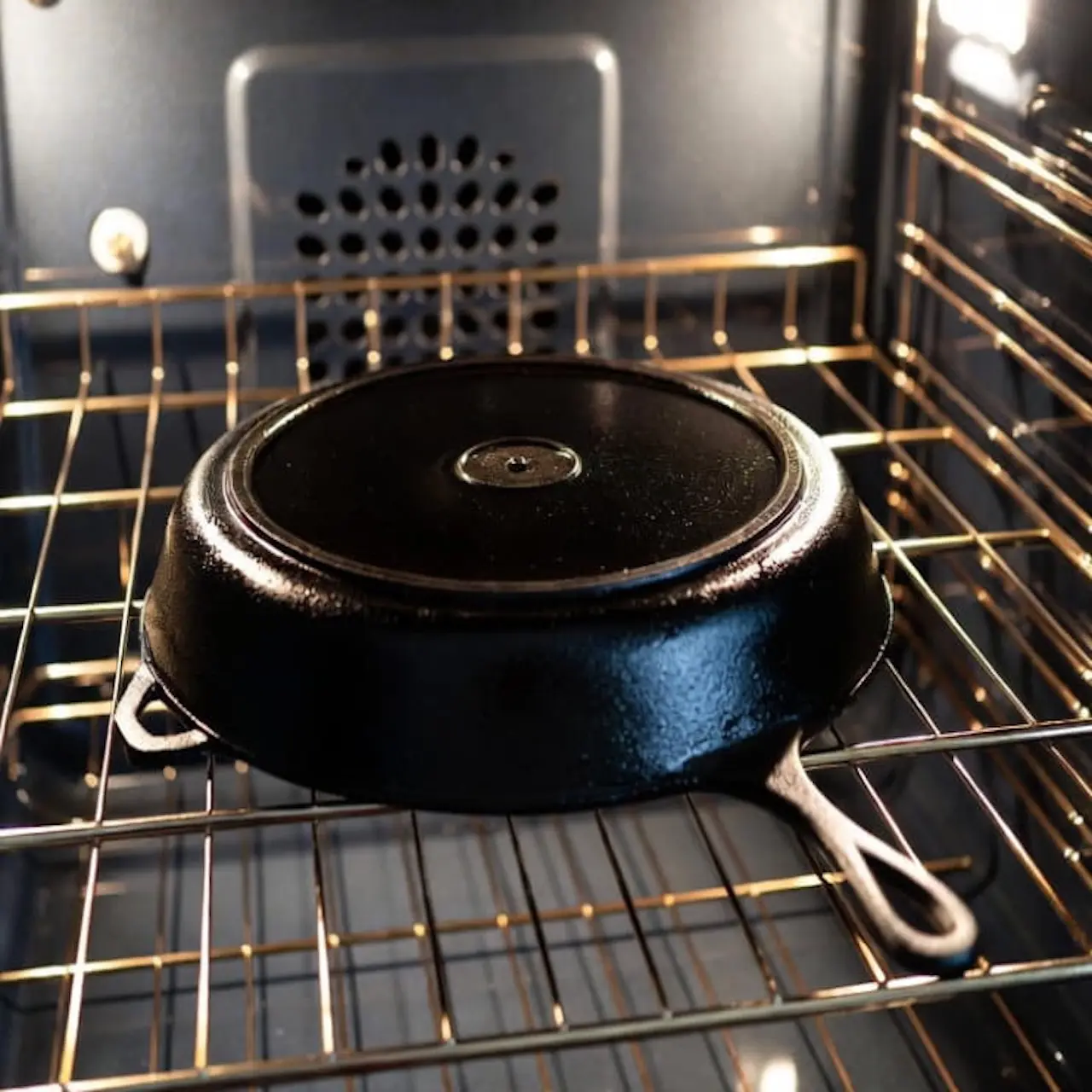 Sartén de hierro fundido boca abajo en el horno para polimerizar el aceite a alta temperatura